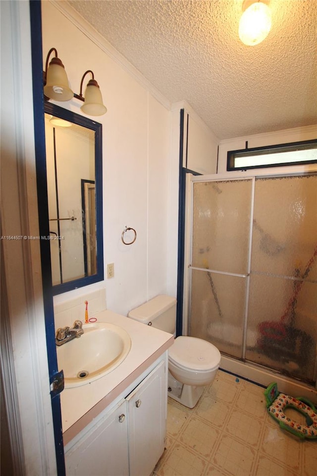 bathroom with tile patterned floors, a textured ceiling, vanity, toilet, and a shower with door