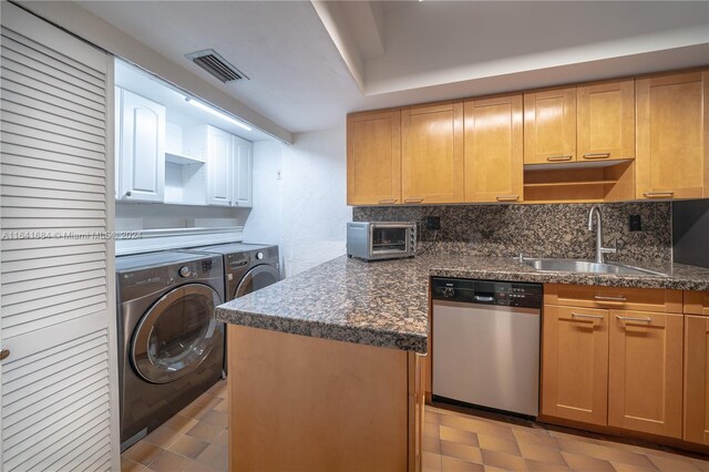 kitchen featuring decorative backsplash, stainless steel dishwasher, sink, washer and dryer, and light tile patterned floors