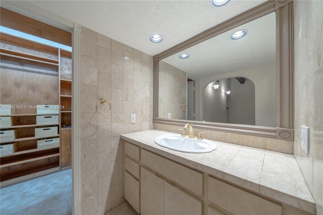 bathroom with recessed lighting, tile walls, and vanity