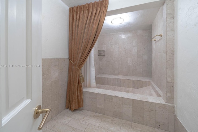 bathroom featuring a tile shower and tile walls