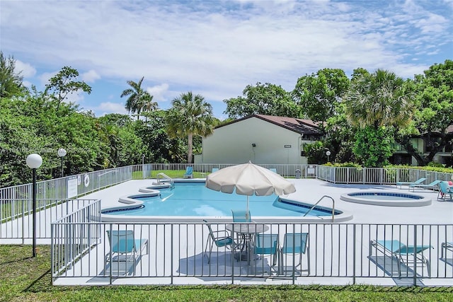 view of pool with a hot tub and a patio area