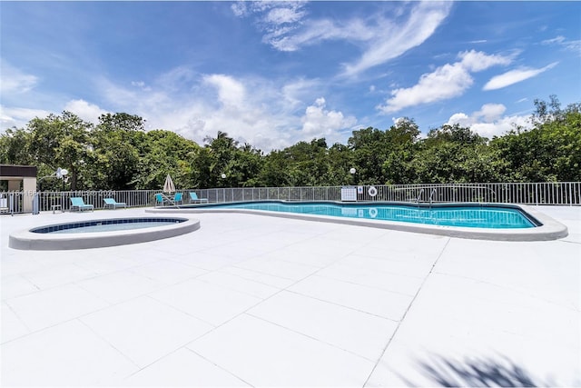 community pool with fence and a patio