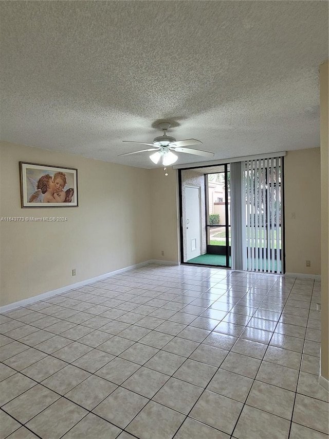 unfurnished room with ceiling fan, light tile patterned flooring, and a textured ceiling