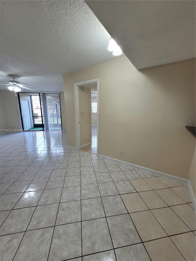 tiled spare room featuring ceiling fan and a textured ceiling