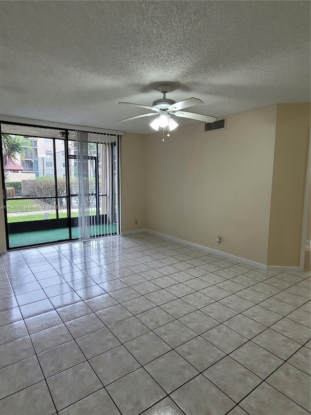 tiled spare room with ceiling fan and a textured ceiling