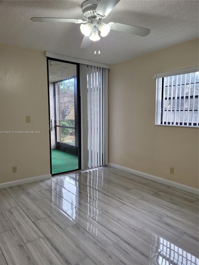 spare room with ceiling fan, light hardwood / wood-style flooring, and a textured ceiling