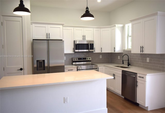 kitchen featuring pendant lighting, sink, white cabinets, and stainless steel appliances