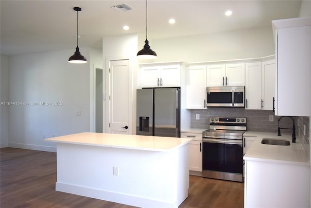 kitchen featuring pendant lighting, a kitchen island, white cabinetry, and stainless steel appliances