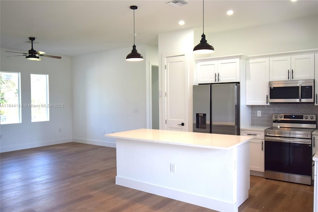 kitchen featuring backsplash, white cabinetry, a center island, and stainless steel appliances