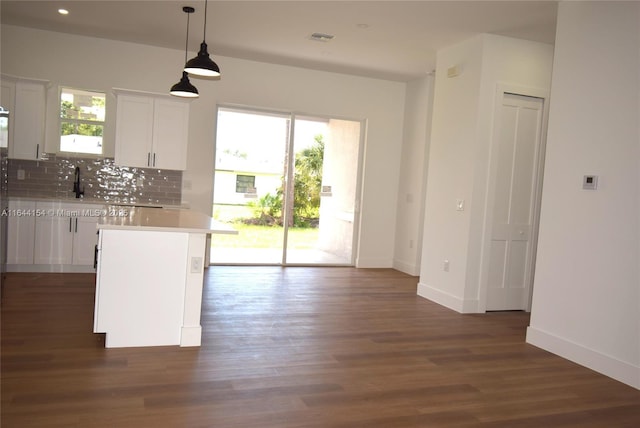 kitchen with a center island, tasteful backsplash, dark hardwood / wood-style floors, decorative light fixtures, and white cabinets