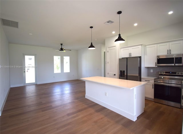 kitchen featuring white cabinetry, a center island, ceiling fan, stainless steel appliances, and decorative backsplash