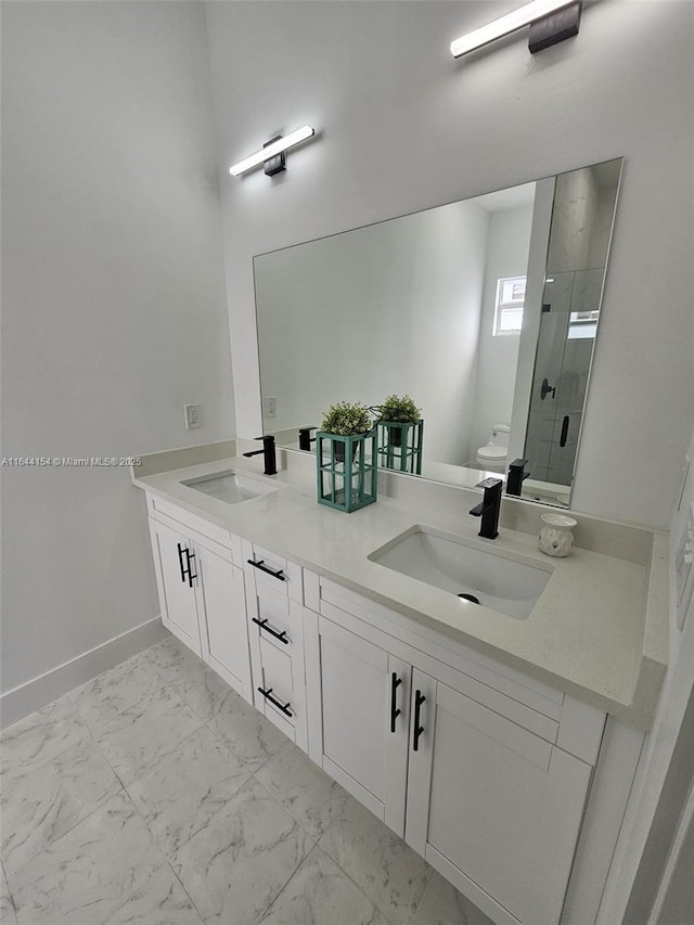 bathroom with vanity, toilet, and a shower with door