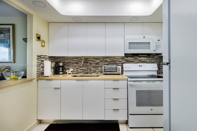 kitchen featuring backsplash, white appliances, white cabinetry, and sink