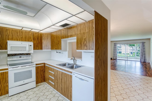 kitchen with sink, white appliances, and light wood-type flooring