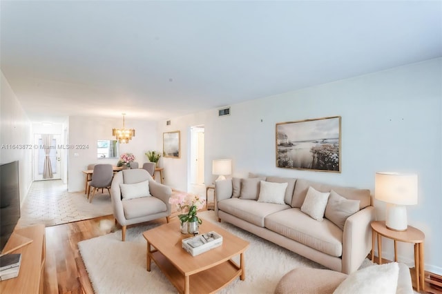 living room with an inviting chandelier and light hardwood / wood-style flooring