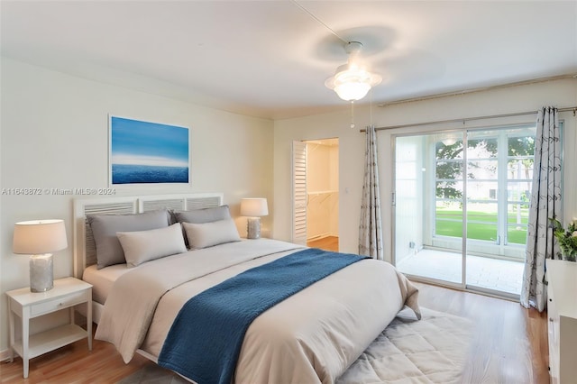 bedroom featuring hardwood / wood-style floors, a walk in closet, ceiling fan, access to exterior, and a closet