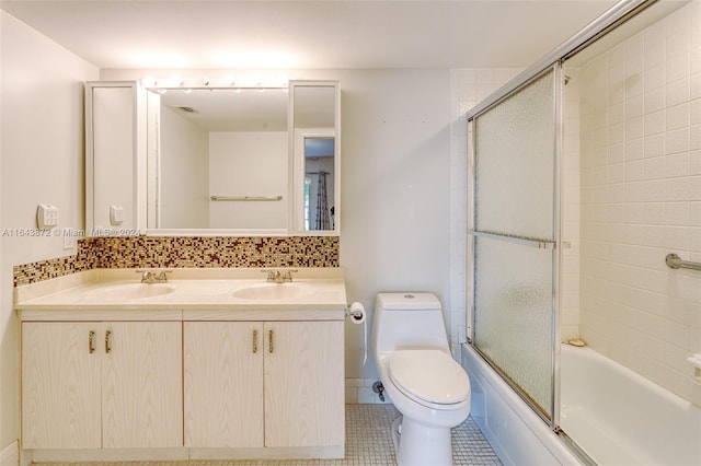 full bathroom featuring tile patterned flooring, vanity, toilet, and bath / shower combo with glass door