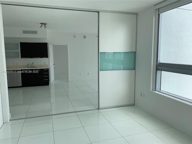 unfurnished bedroom with sink and light tile patterned floors