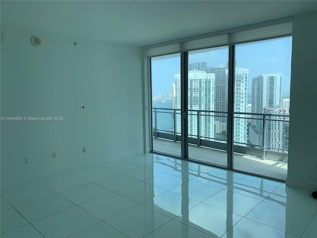 unfurnished room featuring floor to ceiling windows and light tile patterned floors