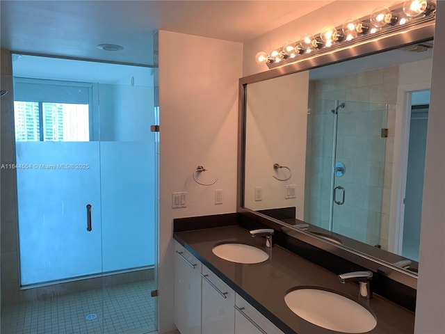 bathroom with an enclosed shower, vanity, and tile patterned flooring