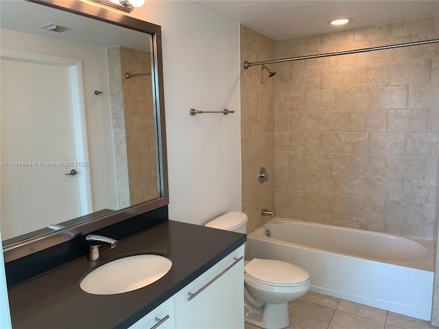 full bathroom featuring toilet, tiled shower / bath, tile patterned flooring, and vanity