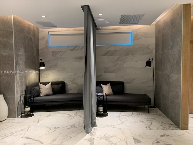 bathroom featuring a shower and tile walls