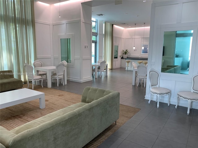 living room with a towering ceiling and tile patterned flooring