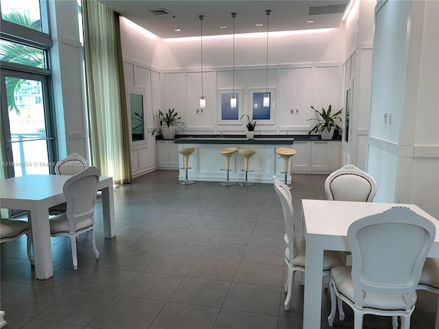 dining room with tile patterned flooring and a towering ceiling