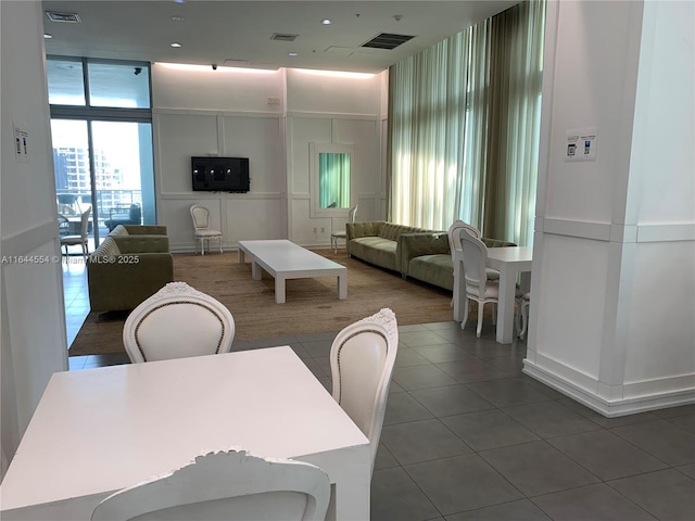 dining space featuring floor to ceiling windows and dark tile patterned flooring