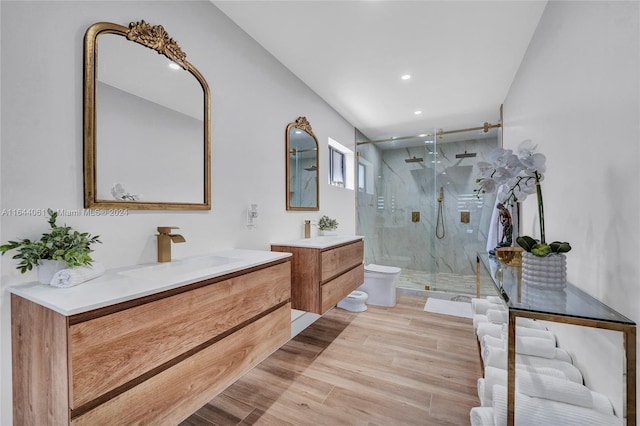 bathroom with hardwood / wood-style flooring, toilet, vanity, and a shower with shower door