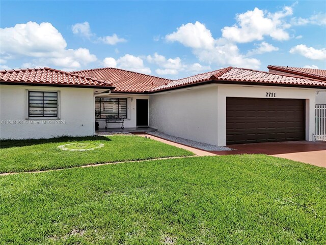 mediterranean / spanish-style home with a front yard and a garage