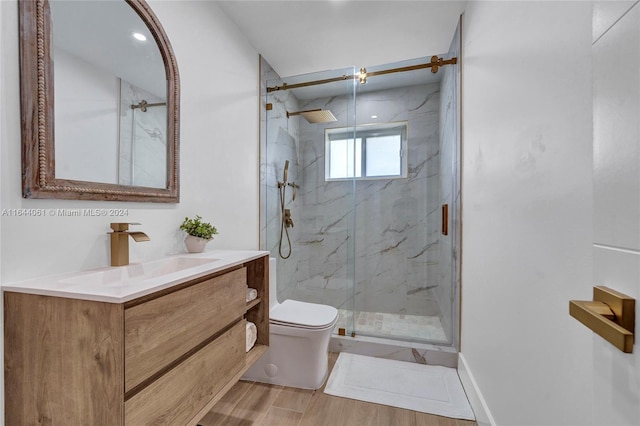 bathroom featuring hardwood / wood-style flooring, toilet, walk in shower, and vanity