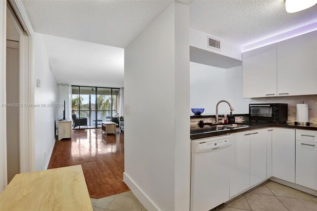 6219 Coral Lake Dr Unit 207, Margate, FL 33063 - kitchen featuring visible vents, dishwasher, dark countertops, a sink, and light tile patterned floors