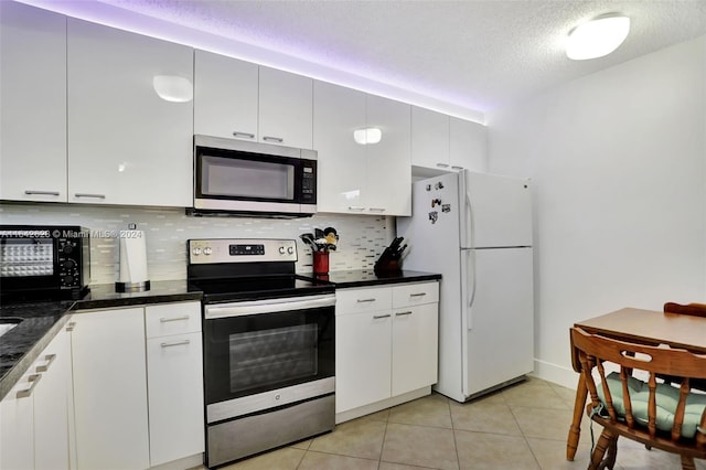 6219 Coral Lake Dr Unit 207, Margate, FL 33063 - kitchen with appliances with stainless steel finishes, a textured ceiling, light tile patterned floors, dark countertops, and decorative backsplash