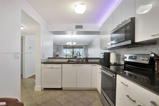 kitchen featuring sink, a notable chandelier, a textured ceiling, light tile patterned floors, and stainless steel appliances