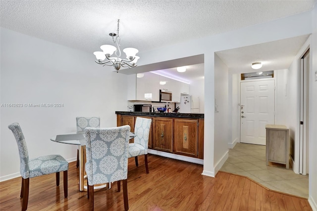 6219 Coral Lake Dr Unit 207, Margate, FL 33063 - dining room with a textured ceiling, light wood-type flooring, and a notable chandelier