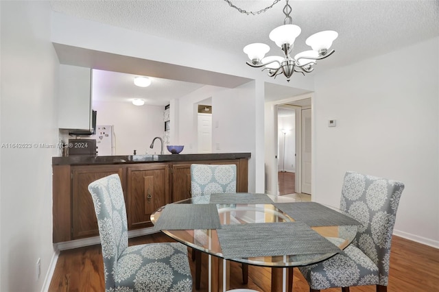 6219 Coral Lake Dr Unit 207, Margate, FL 33063 - dining space featuring baseboards, dark wood-style flooring, a textured ceiling, and a chandelier
