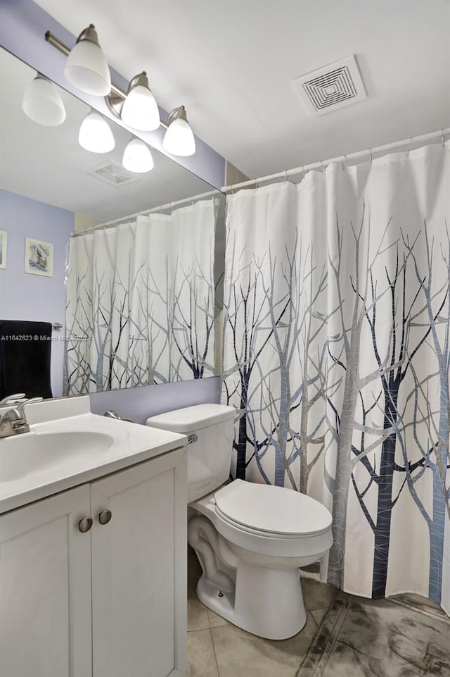 bathroom featuring tile patterned floors, toilet, walk in shower, and vanity