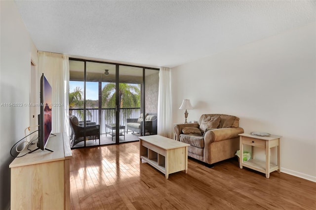 living room featuring a textured ceiling, expansive windows, and hardwood / wood-style floors