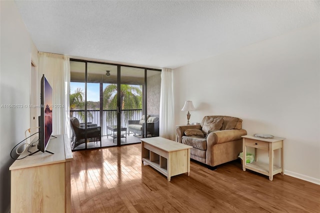 6219 Coral Lake Dr Unit 207, Margate, FL 33063 - living room featuring baseboards, floor to ceiling windows, a textured ceiling, and wood finished floors