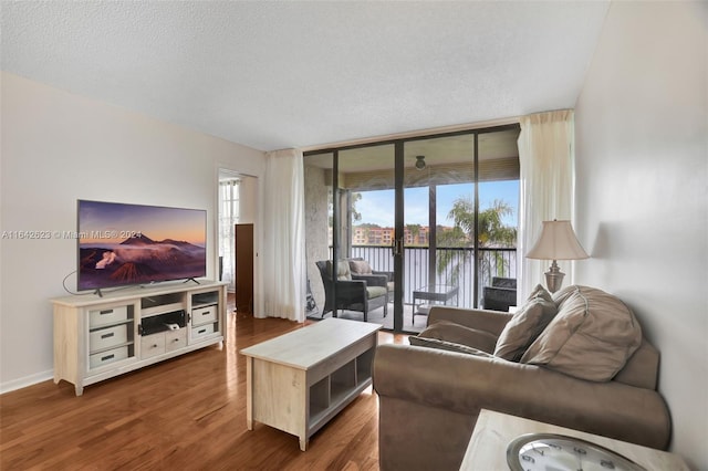 6219 Coral Lake Dr Unit 207, Margate, FL 33063 - living room featuring a textured ceiling, expansive windows, a wealth of natural light, and dark wood-style flooring