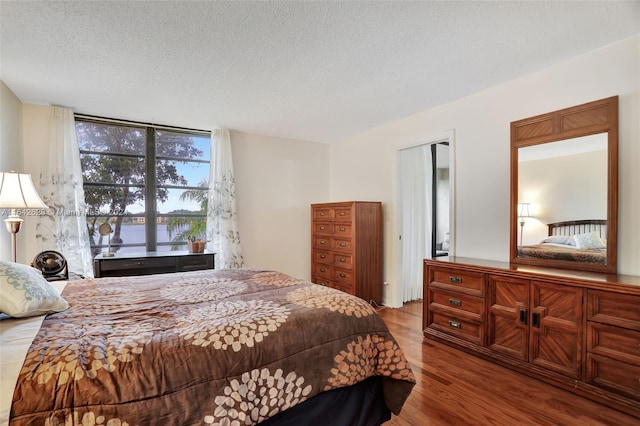 6219 Coral Lake Dr Unit 207, Margate, FL 33063 - bedroom featuring a wall of windows, wood finished floors, and a textured ceiling