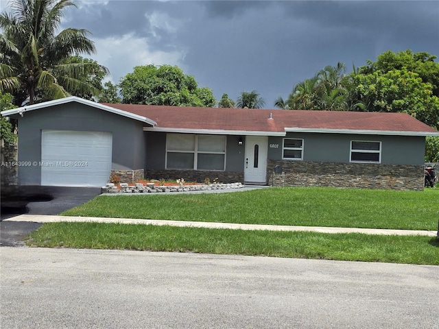 ranch-style house featuring a garage and a front yard