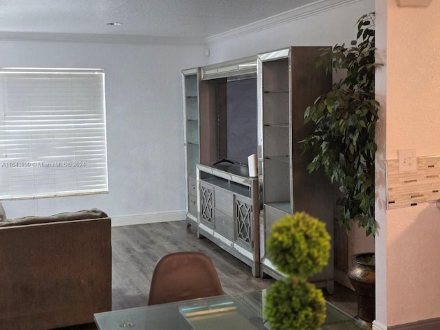 living room featuring a textured ceiling, crown molding, and hardwood / wood-style flooring