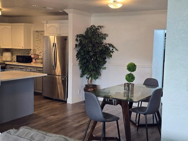 dining space with dark wood-type flooring and ornamental molding