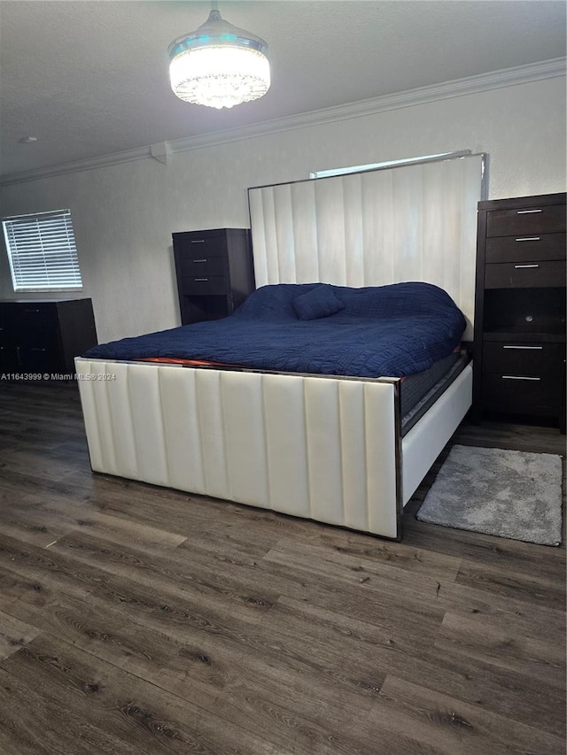 bedroom with ornamental molding and dark hardwood / wood-style floors