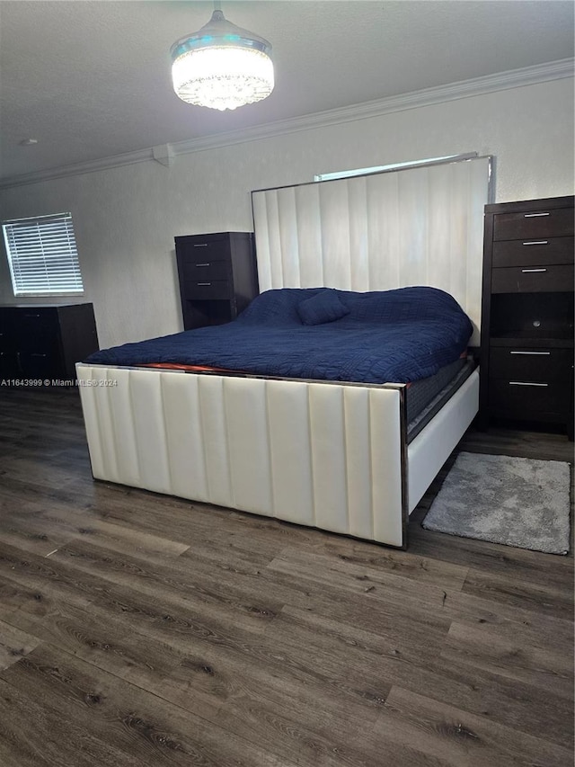 bedroom featuring ornamental molding and dark wood-style flooring