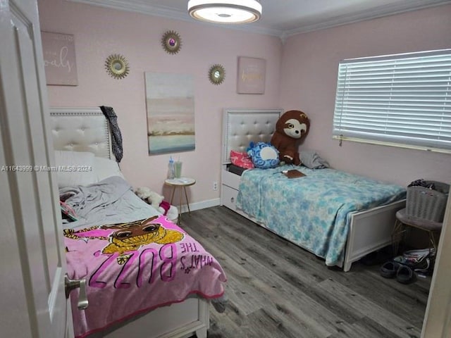 bedroom with ornamental molding, dark wood finished floors, and baseboards