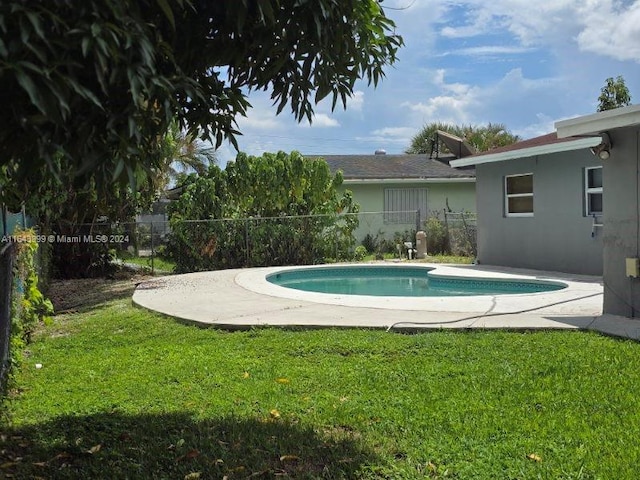 view of swimming pool with fence, a yard, and a fenced in pool