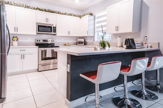 kitchen with light countertops, a breakfast bar, and stainless steel appliances